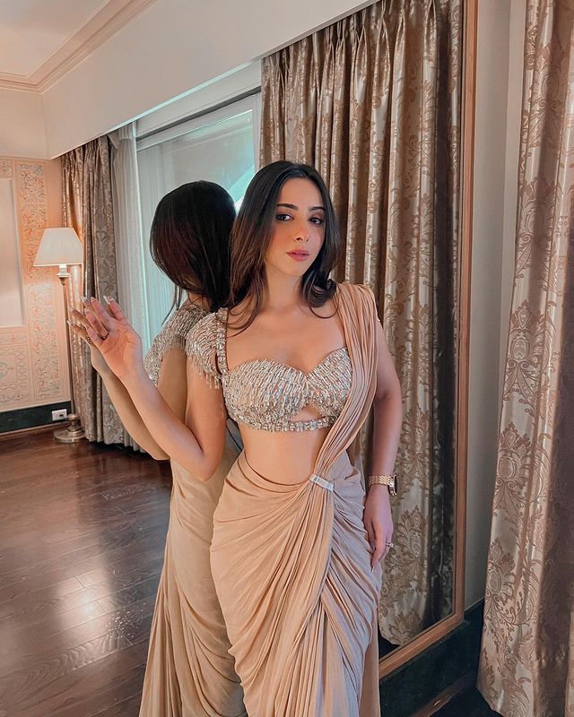 Soumya Chawla in Nude Drape Saree With Bralette Blouse & Tasseled Sleeves